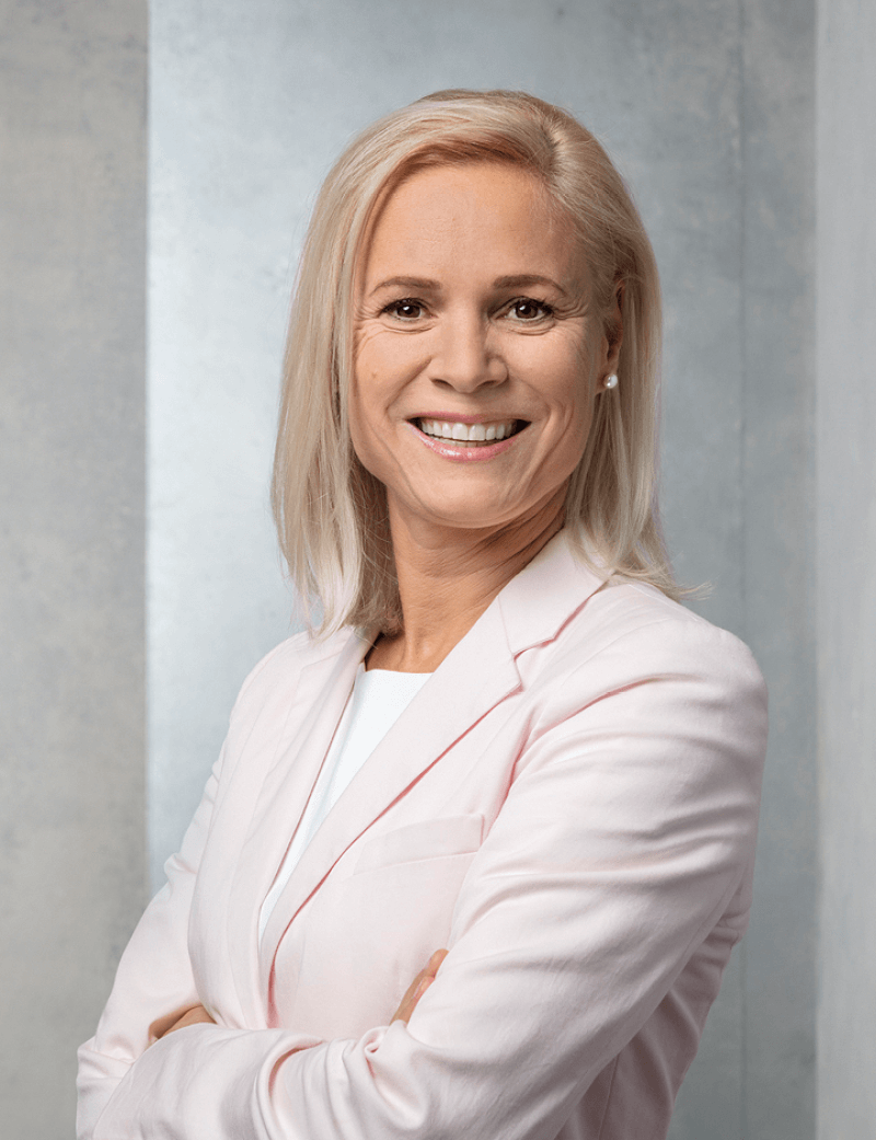 Frau stehend in hellem Anzug, Arme verschränkt: Dr. Joy Müller