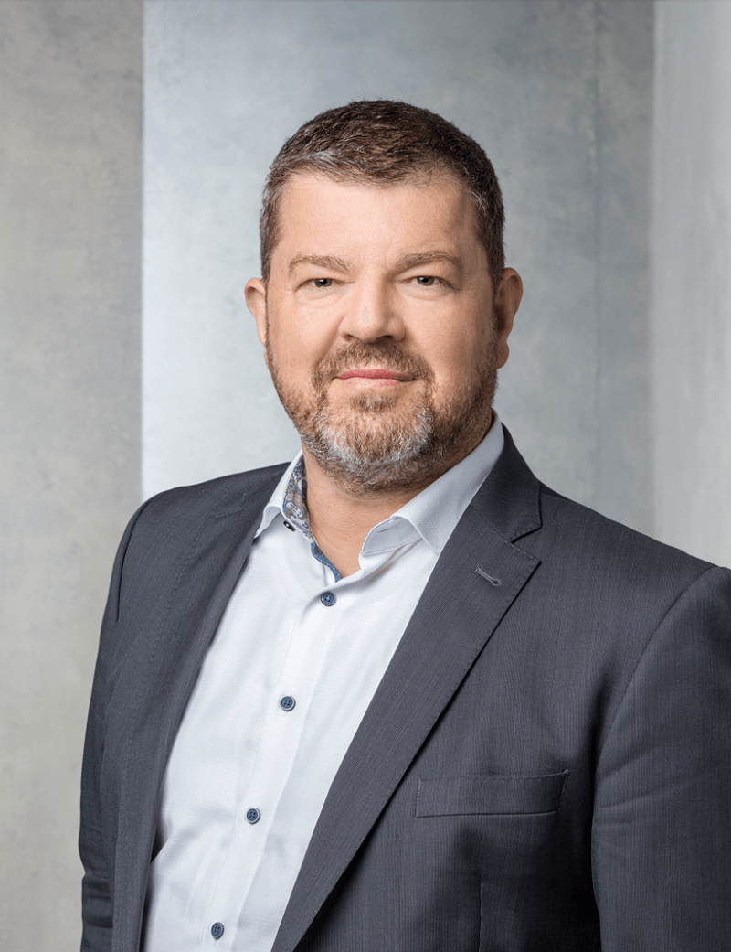 Mann stehend in dunklem Anzug vor grauem Hintergrund: Dr. Reto Dahinden, CEO SWICA