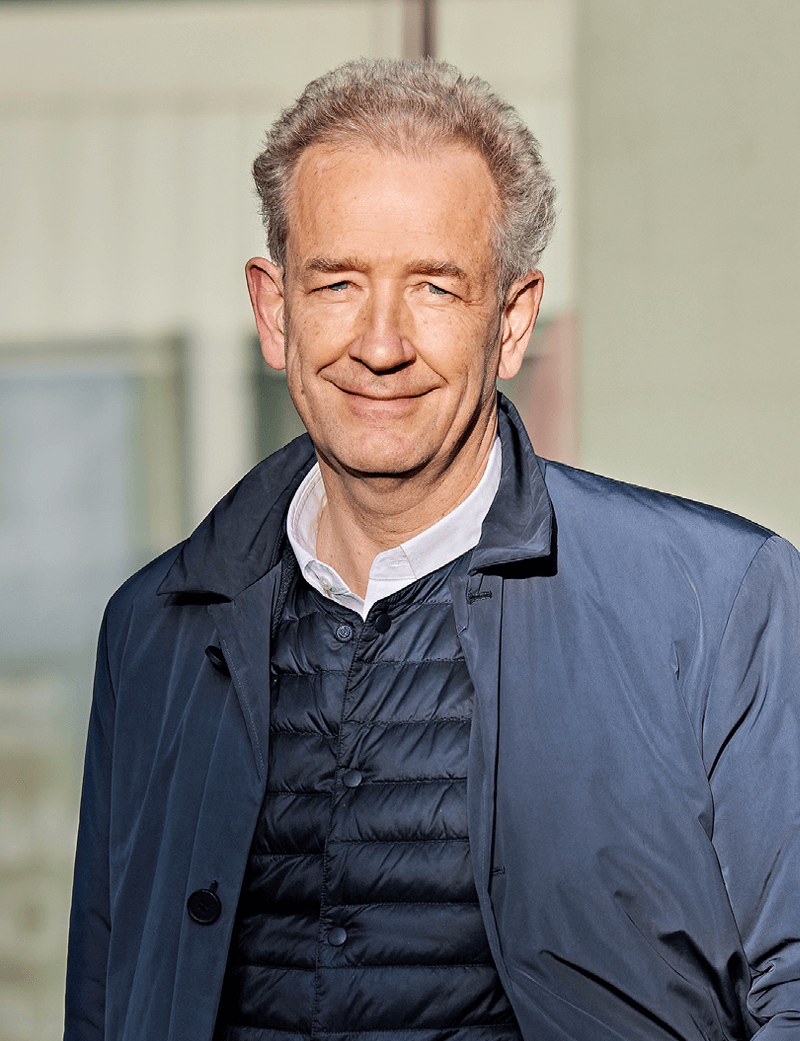 Mann stehend in blauer Jacke, der lächelt: Adrian Bult