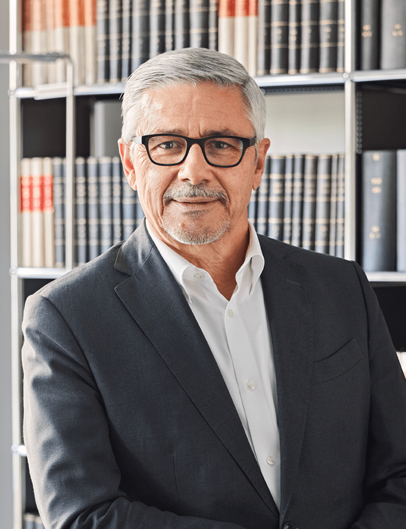 Mann stehend in dunklem Anzug und schwarzer Brille vor grauem Hintergrund: Dr. Carlo Conti, Verwaltungsratspräsident SWICA