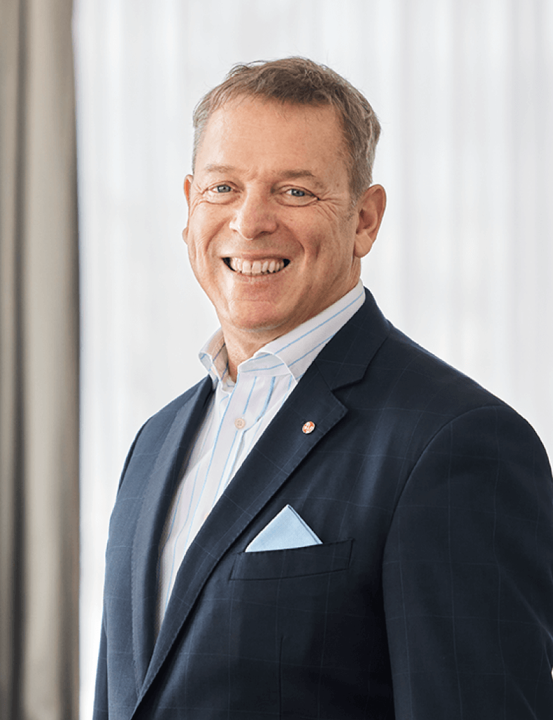 Mann stehend in Anzug, der lächelt: Casimir Platzer