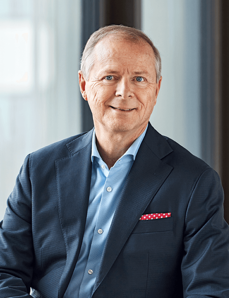 Mann sitzend in Anzug, der lächelt: Martin Wenk