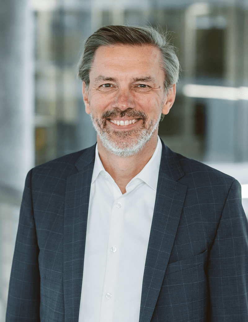 Mann stehend in Anzug, der lächelt: Rolf Birrer