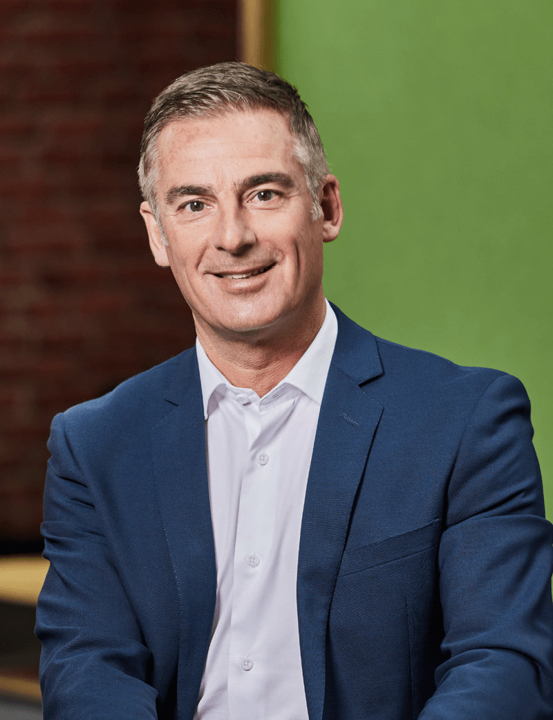 Mann sitzend in Anzug, der lächelt: Stefan Loacker