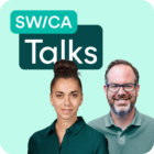 Eine Frau und ein Mann stehen vor einem grünen Hintergrund.